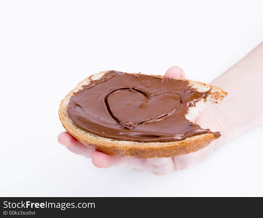 Slice of bread with choco paste in hand on the white background