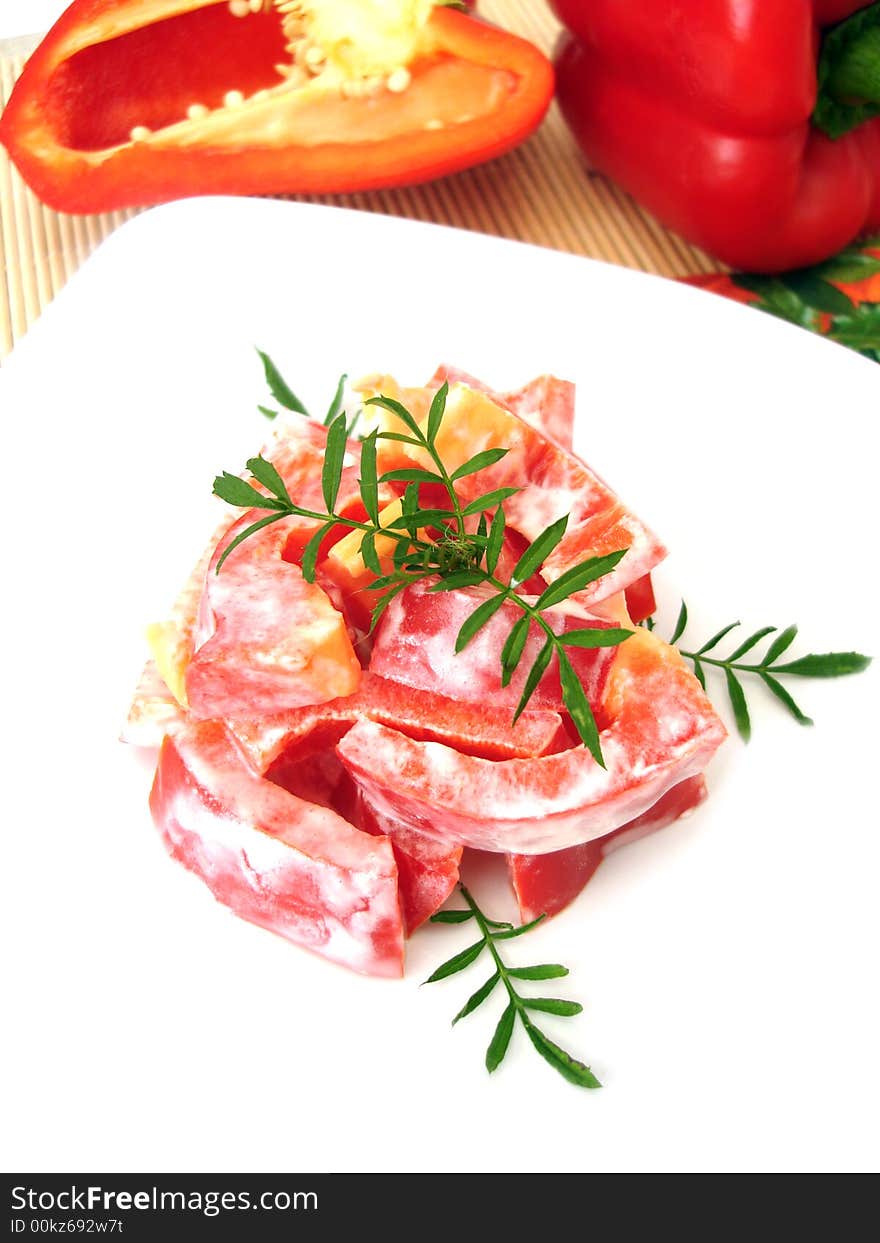 Salad with red pepper on white plate