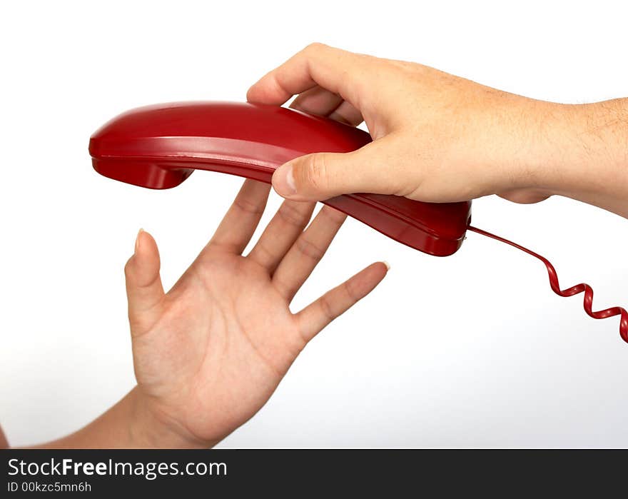 A hand passing a red phone while another hand reaches for it. A hand passing a red phone while another hand reaches for it