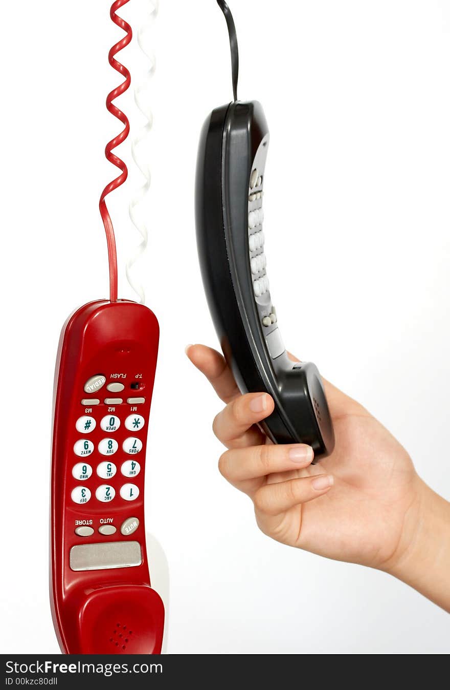 Handset phones hanging over a white background. Handset phones hanging over a white background