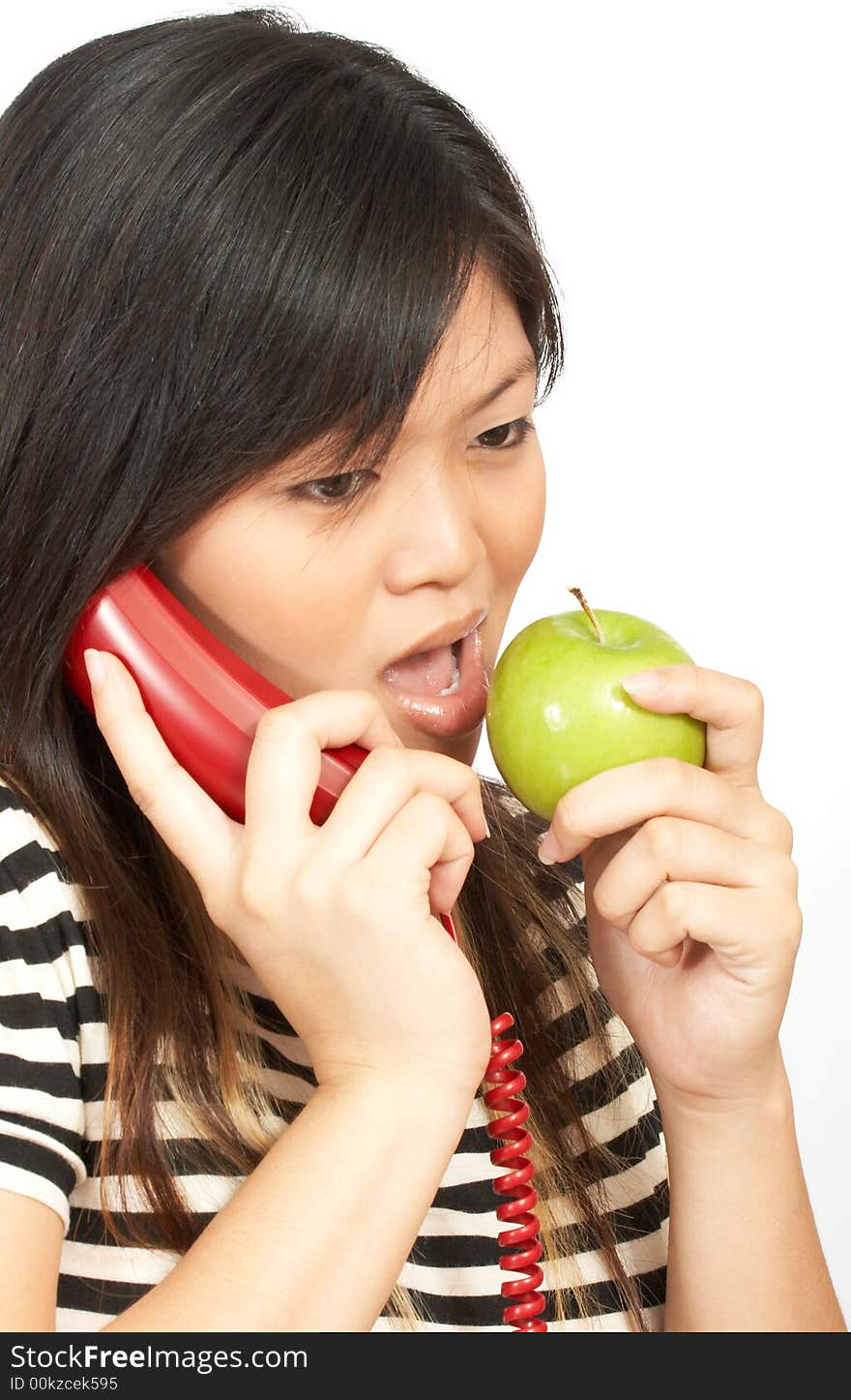 A woman eating an apple while on the phone. A woman eating an apple while on the phone