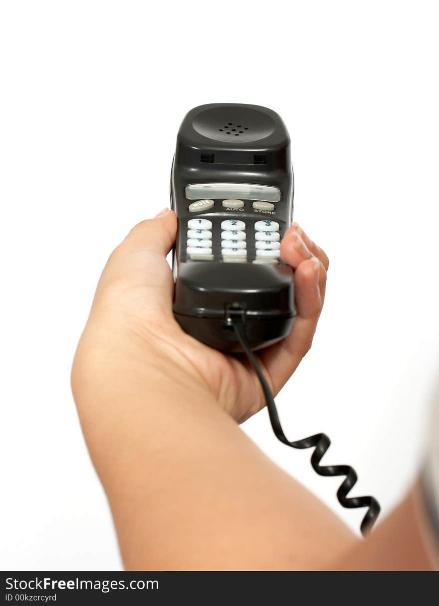 A hand holding a  telephone handset over a white background. A hand holding a  telephone handset over a white background