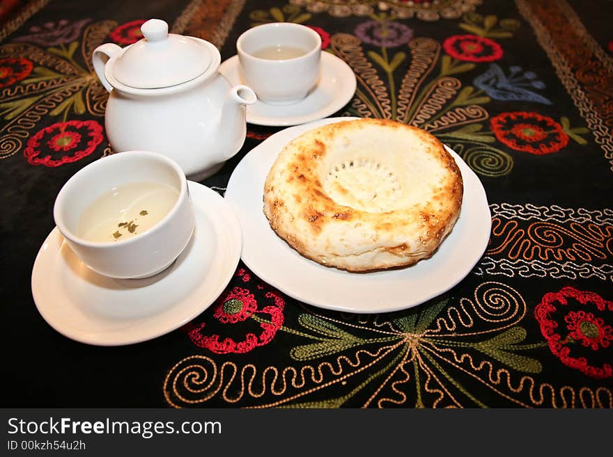 Teapot with cups and griddle on carpet