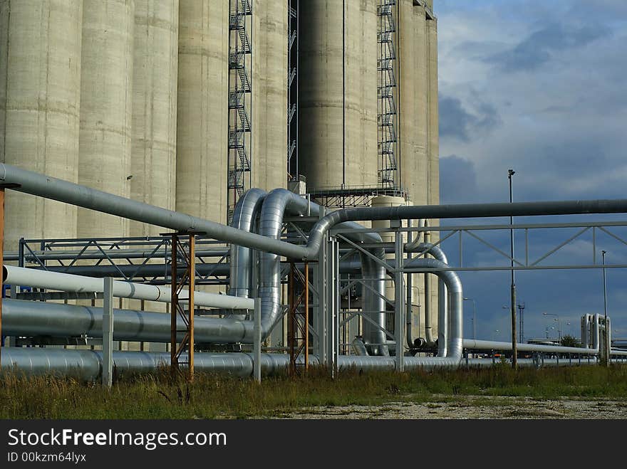 Pipes bridges and concrete silos against blue sky