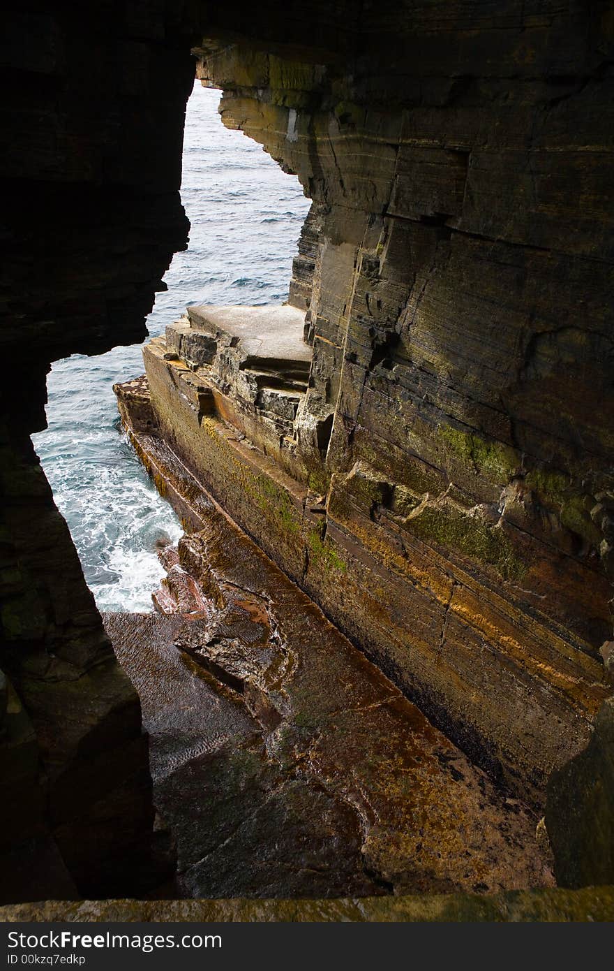 Eroded hole in sandstone cliffs in Orkney. Eroded hole in sandstone cliffs in Orkney