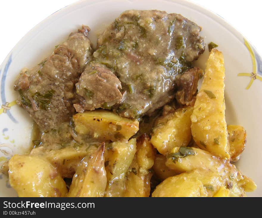 Beef with potatoes on a white plate, isolated. Beef with potatoes on a white plate, isolated