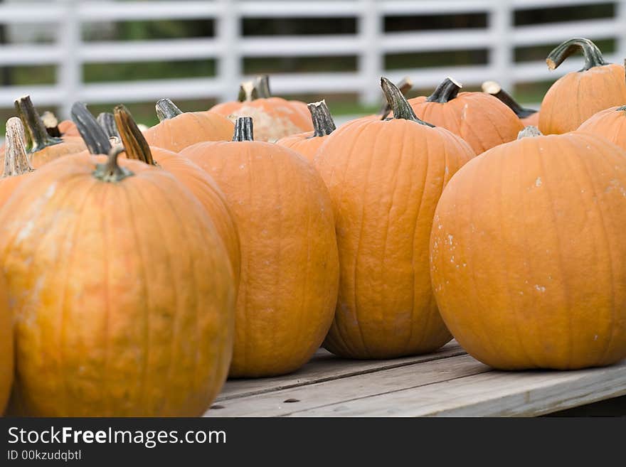 A collection of pumpkins sitting on wooden wagon - for sale. A collection of pumpkins sitting on wooden wagon - for sale.