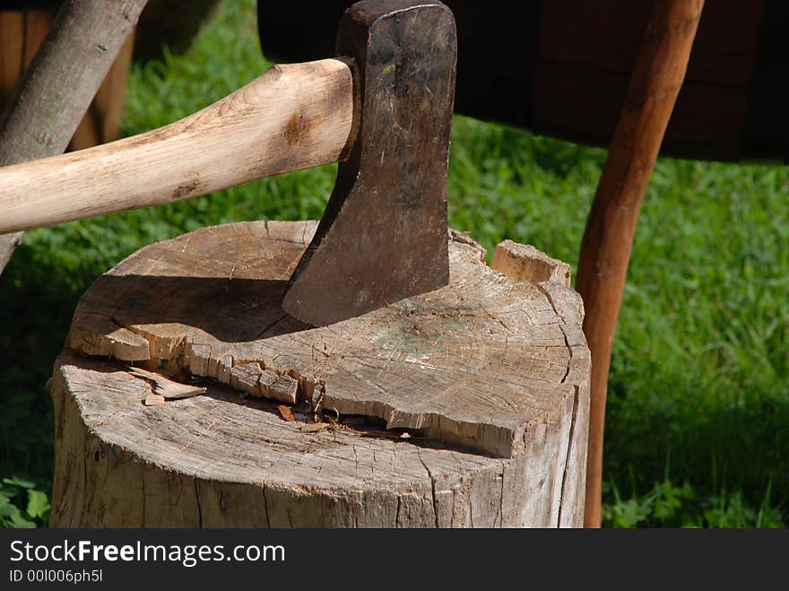 An ax imbedded in a log of wood. An ax imbedded in a log of wood