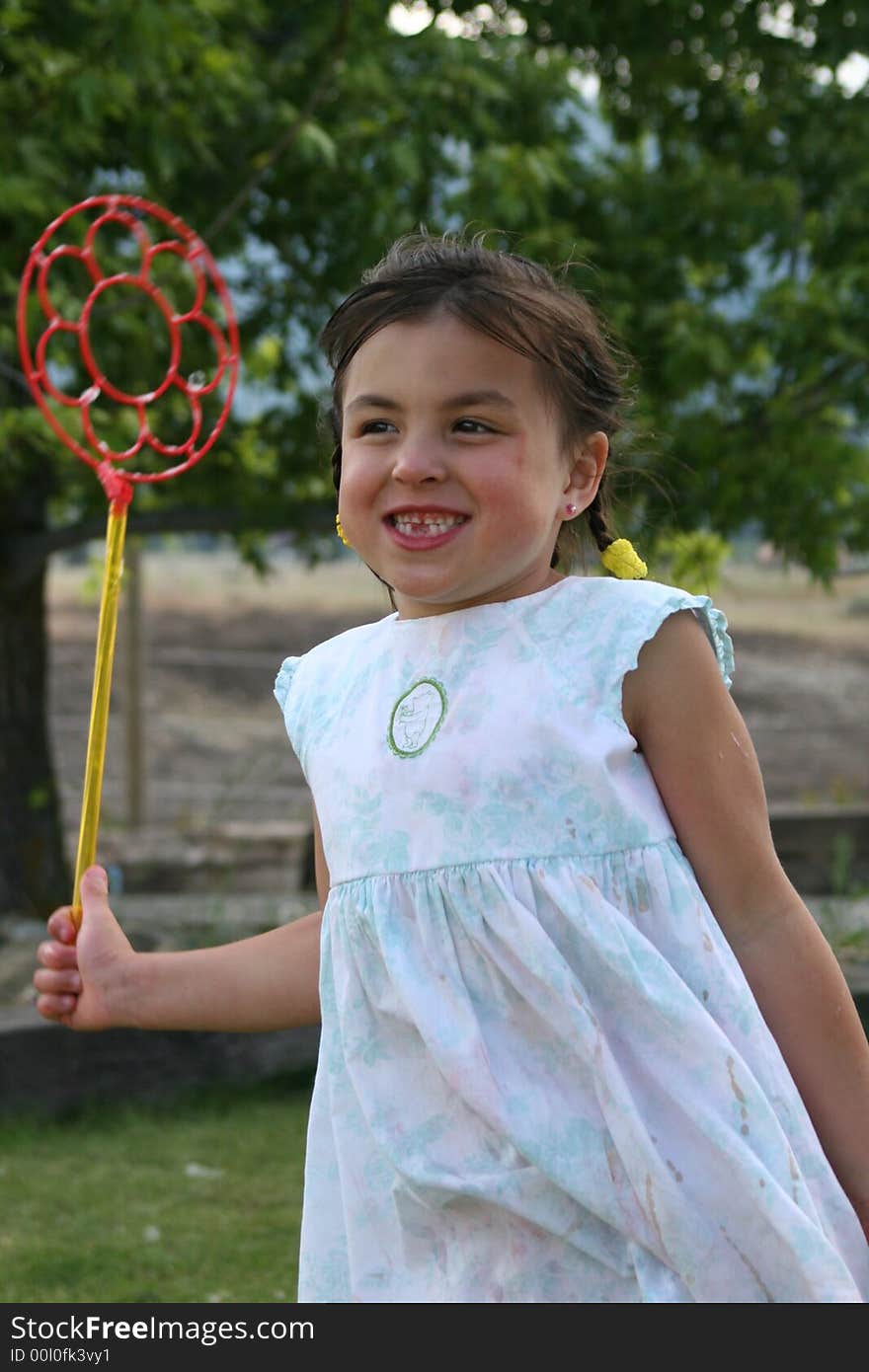 Little girl blowing holding big bubble wand. Little girl blowing holding big bubble wand.