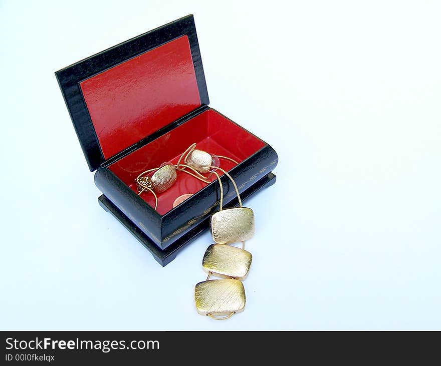 The gold pendant and earrings in the box. The gold pendant and earrings in the box