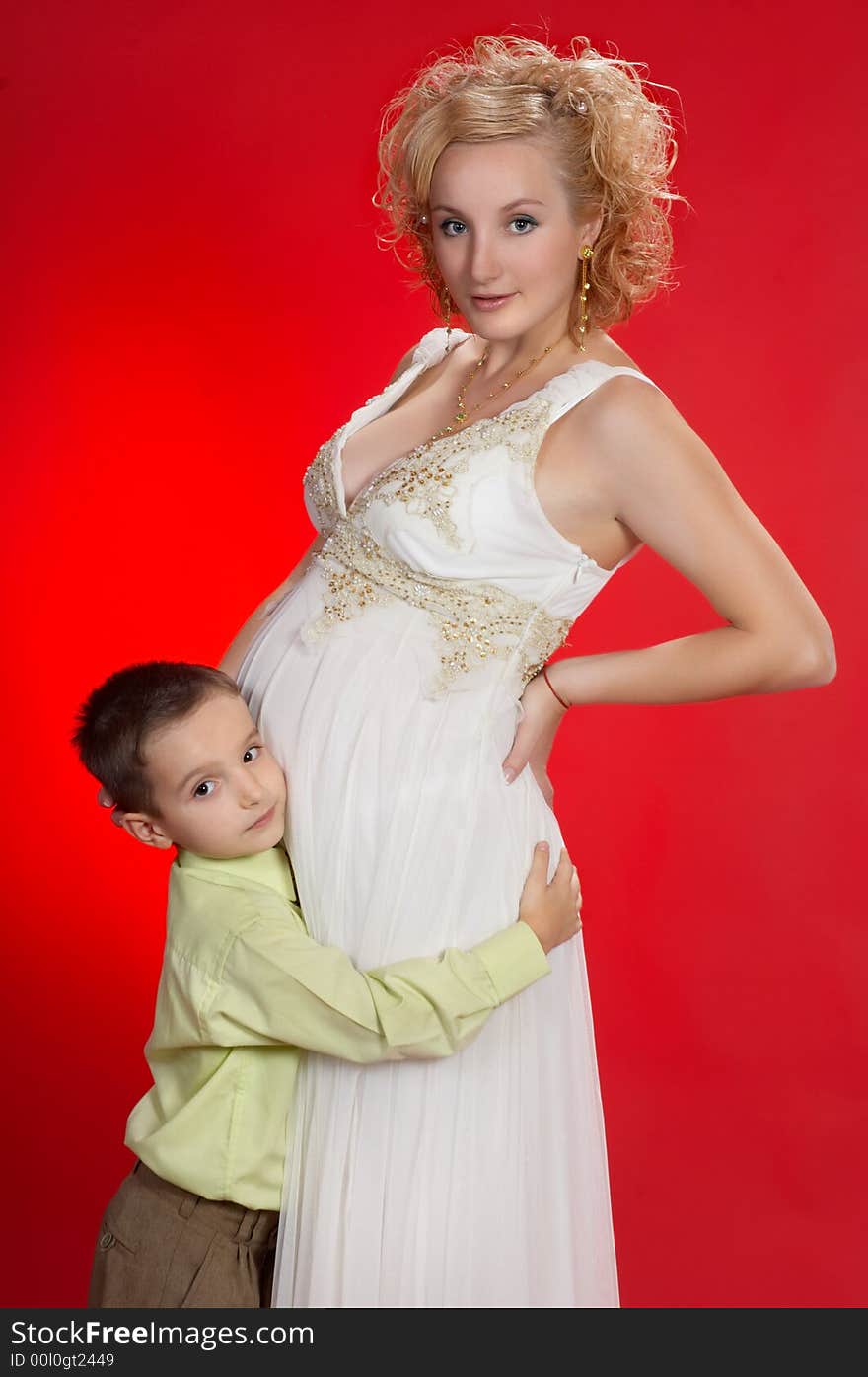 Gorgeous pregnant blond woman with her first child together. on red background. Gorgeous pregnant blond woman with her first child together. on red background.