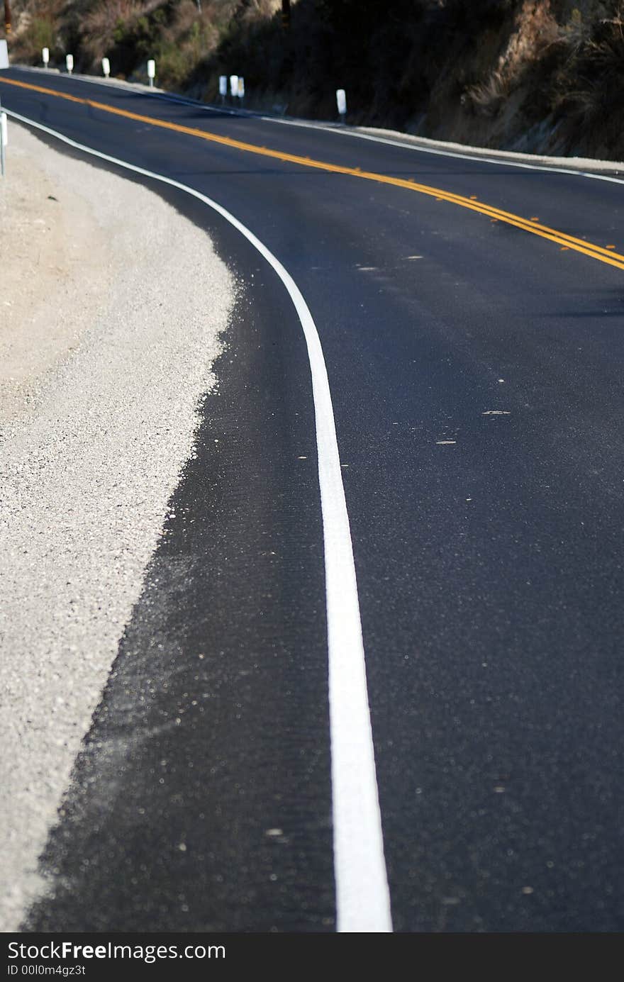 White line freshly painted on new blacktop road. White line freshly painted on new blacktop road