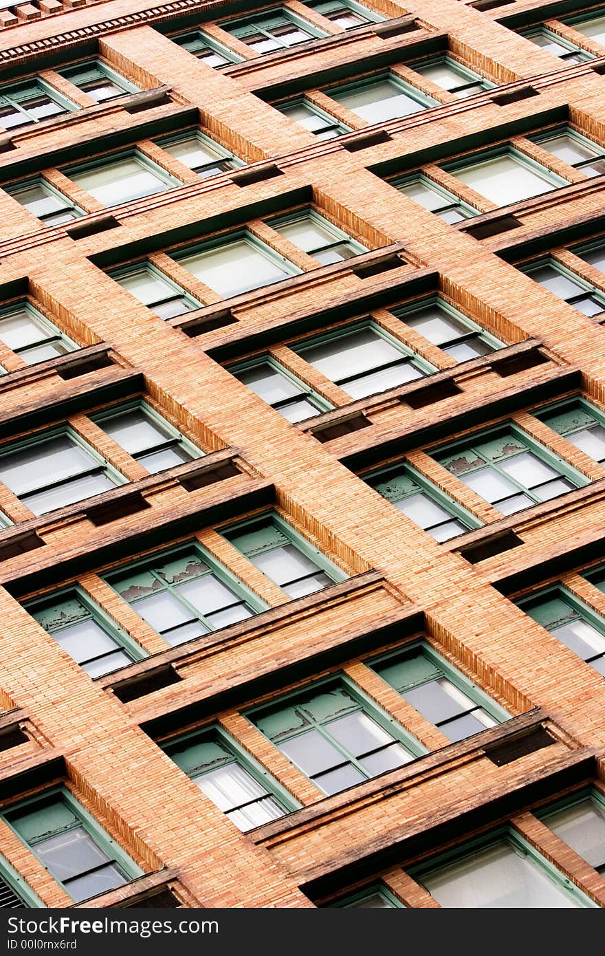 The side of a building composed of windows and red brick. The side of a building composed of windows and red brick.