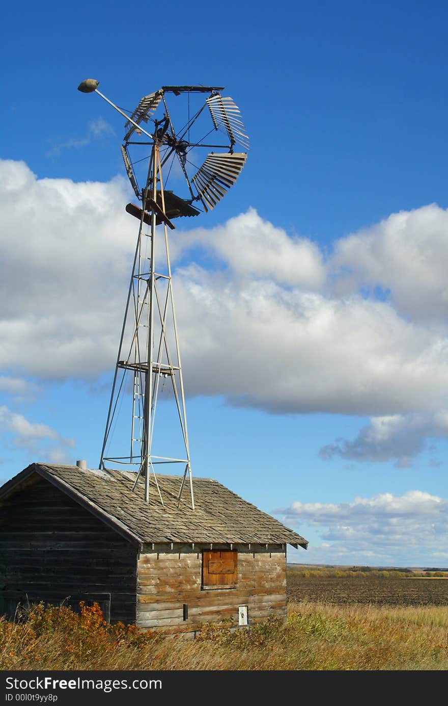 A windmill is built into an old shed or granary on a remote farm in northern Canada. A windmill is built into an old shed or granary on a remote farm in northern Canada