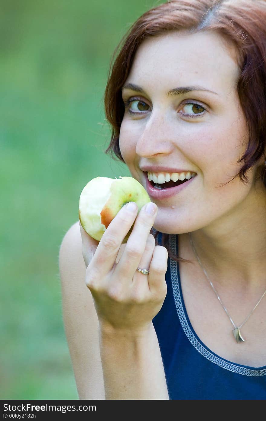 A young woman witch apple  in a park. A young woman witch apple  in a park