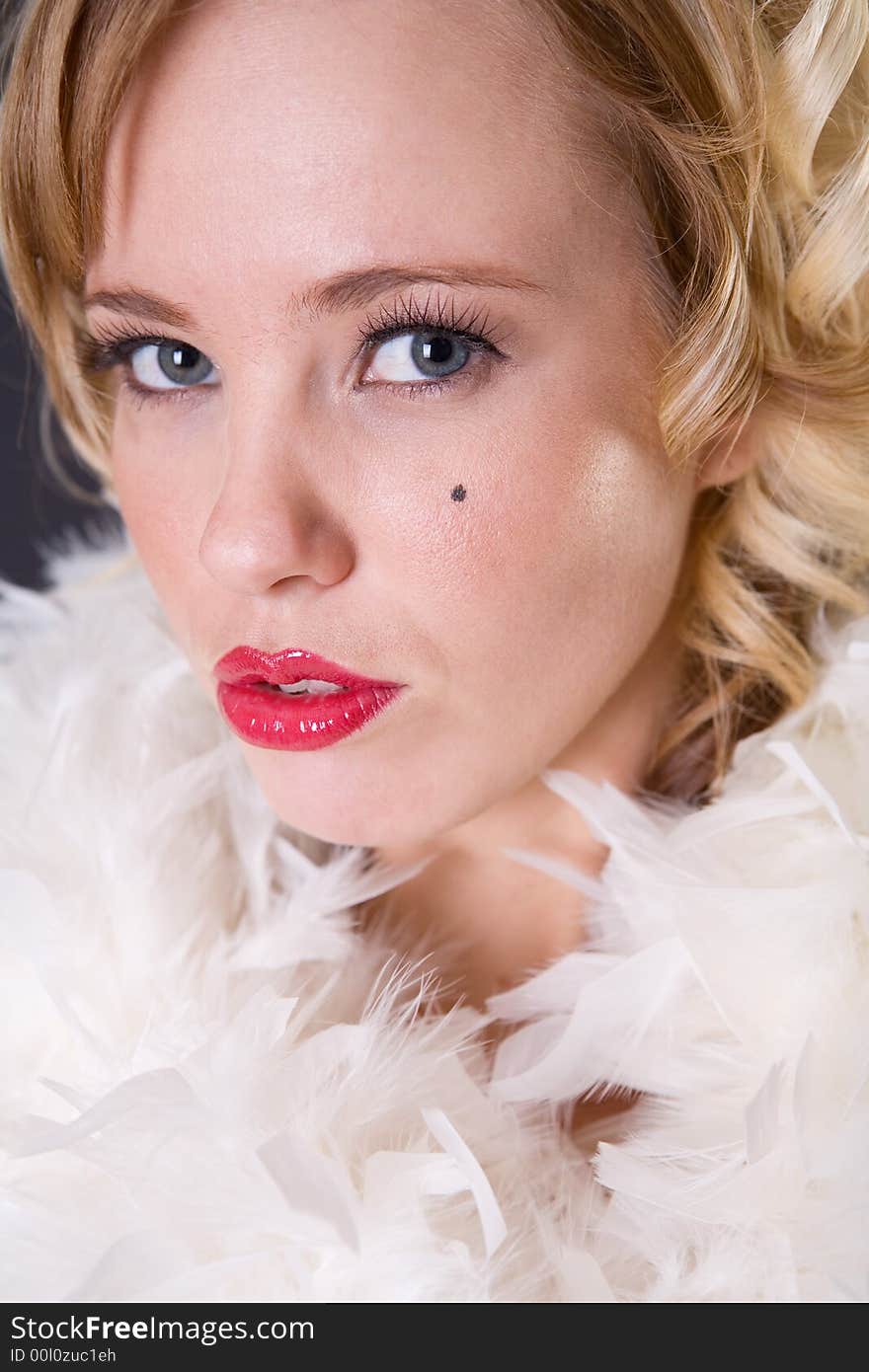 Close up portrait of blonde woman with red lips and feathers