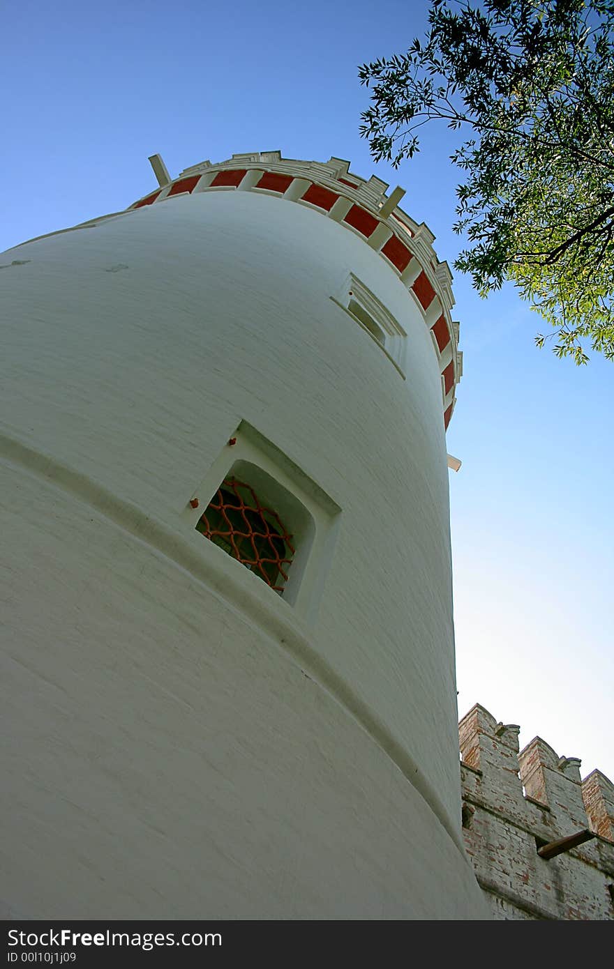 White tower and green branch on a background of the sky. White tower and green branch on a background of the sky