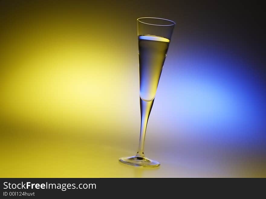 A thin glass filled with water with colorful background. A thin glass filled with water with colorful background