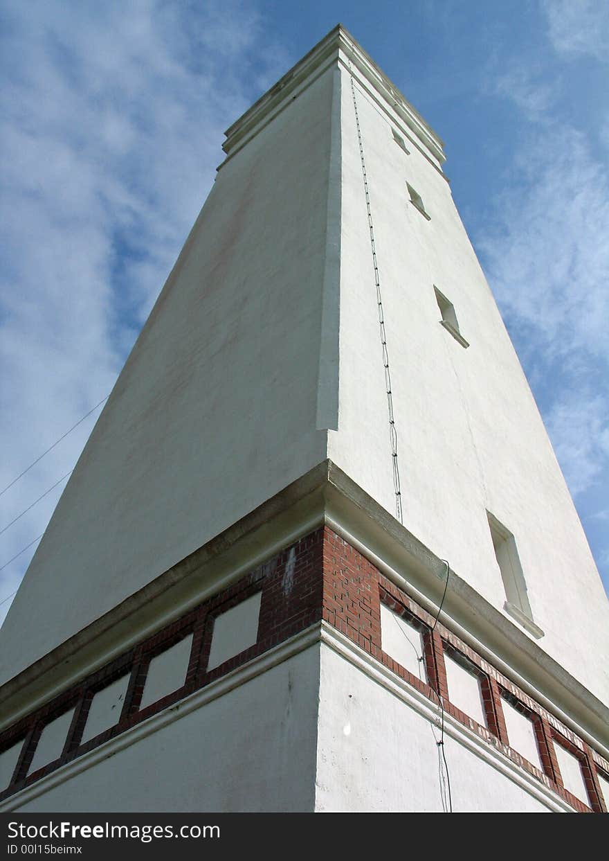 Perspective view of a tall white lighthouse