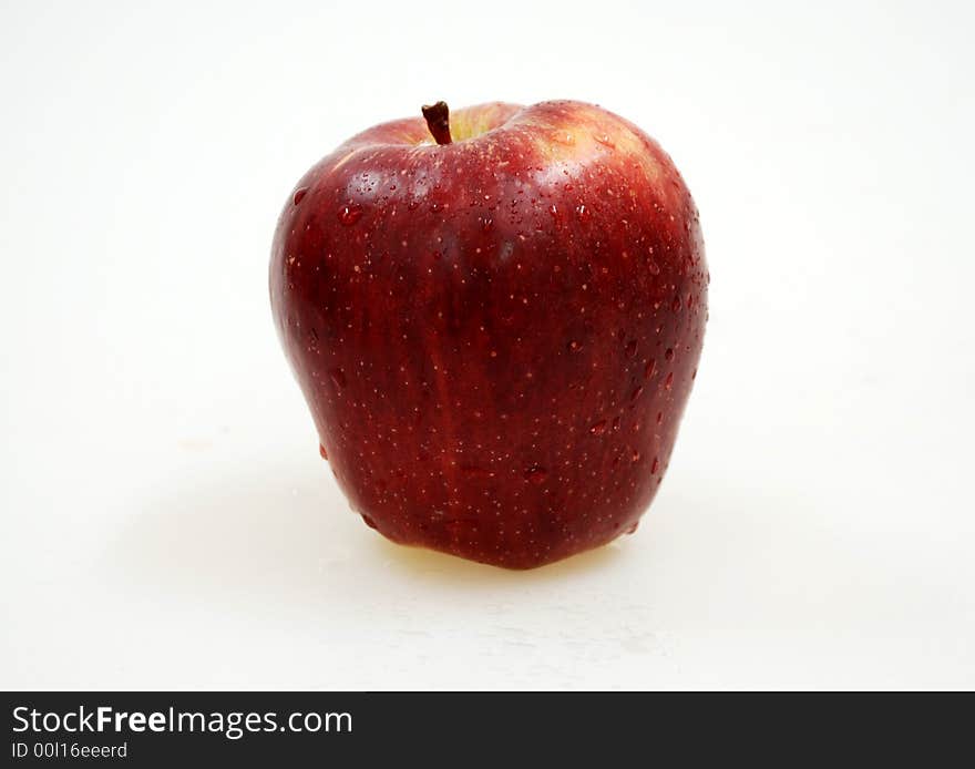 Big red apple with drops on white background