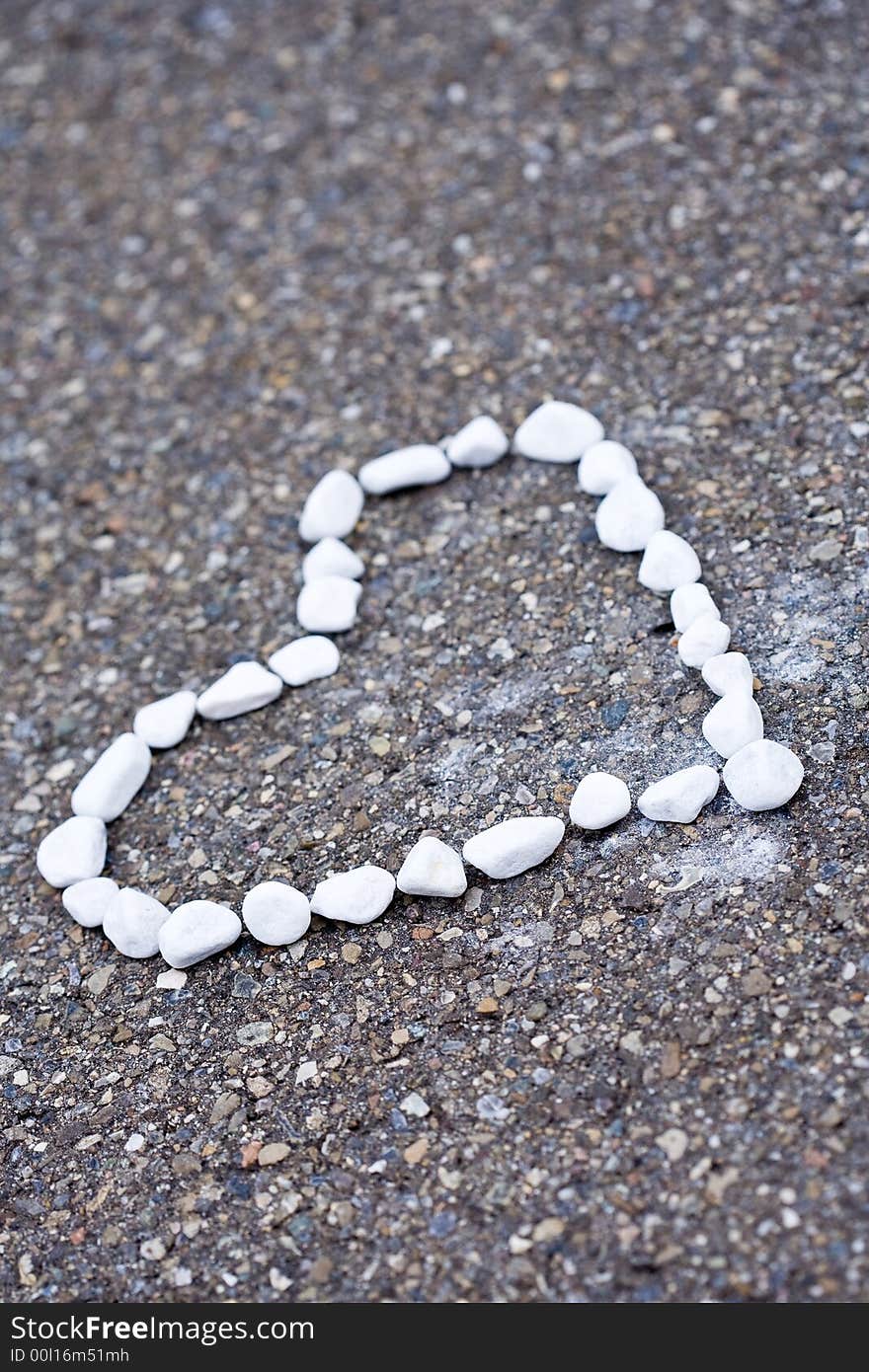 Small white stones heartshaped lying on the street.