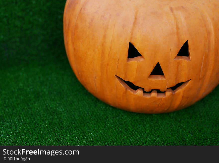 Pumpkin with the cut out person on a green grass