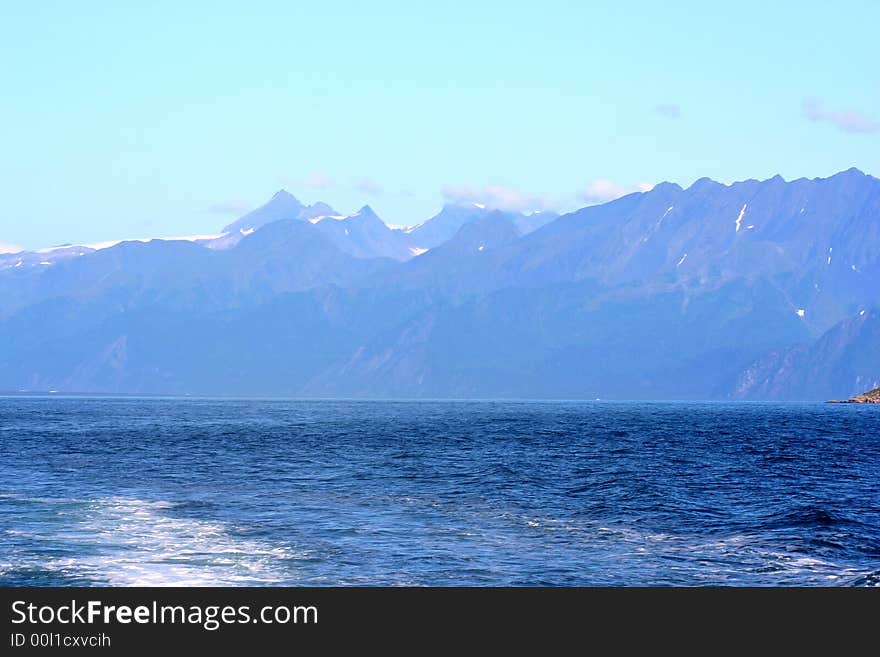 Alaska shorline with snow-covered mountains in background. Alaska shorline with snow-covered mountains in background.