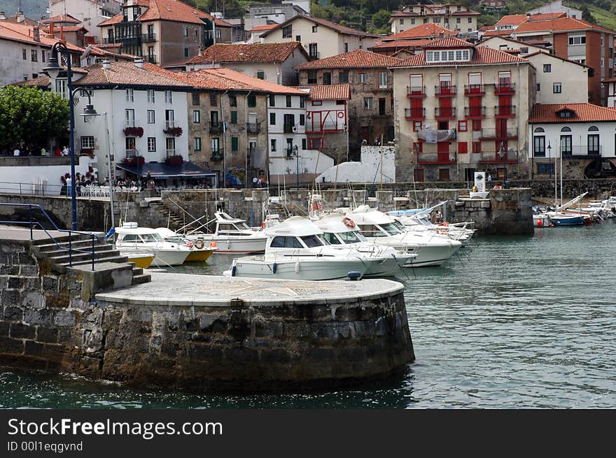 Sseveral yachts anchored in a city docks - old houses behind. Sseveral yachts anchored in a city docks - old houses behind