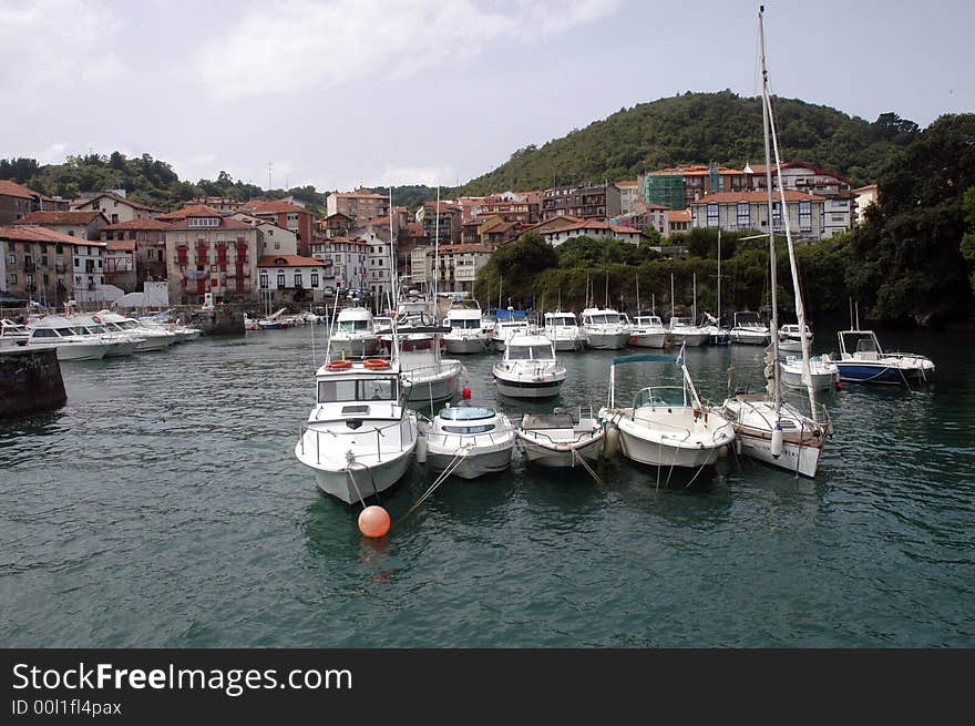 Sseveral yachts anchored in a city docks - old houses behind. Sseveral yachts anchored in a city docks - old houses behind