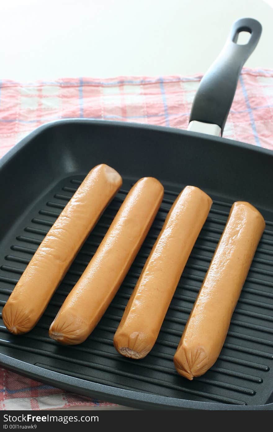 Large eight inch frankfurters on a grill pan for trying. Large eight inch frankfurters on a grill pan for trying