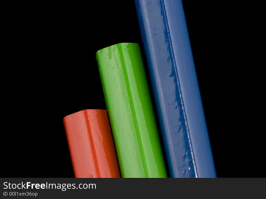 Red, green and blue pencils against dark background. Red, green and blue pencils against dark background