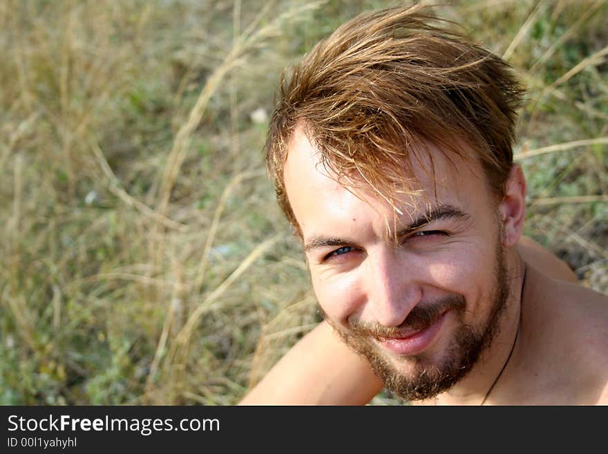 Young handsome man looks straight at the camera and smiles. Young handsome man looks straight at the camera and smiles.