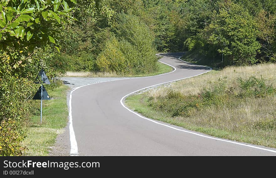 A winding road cutting its way through the countryside