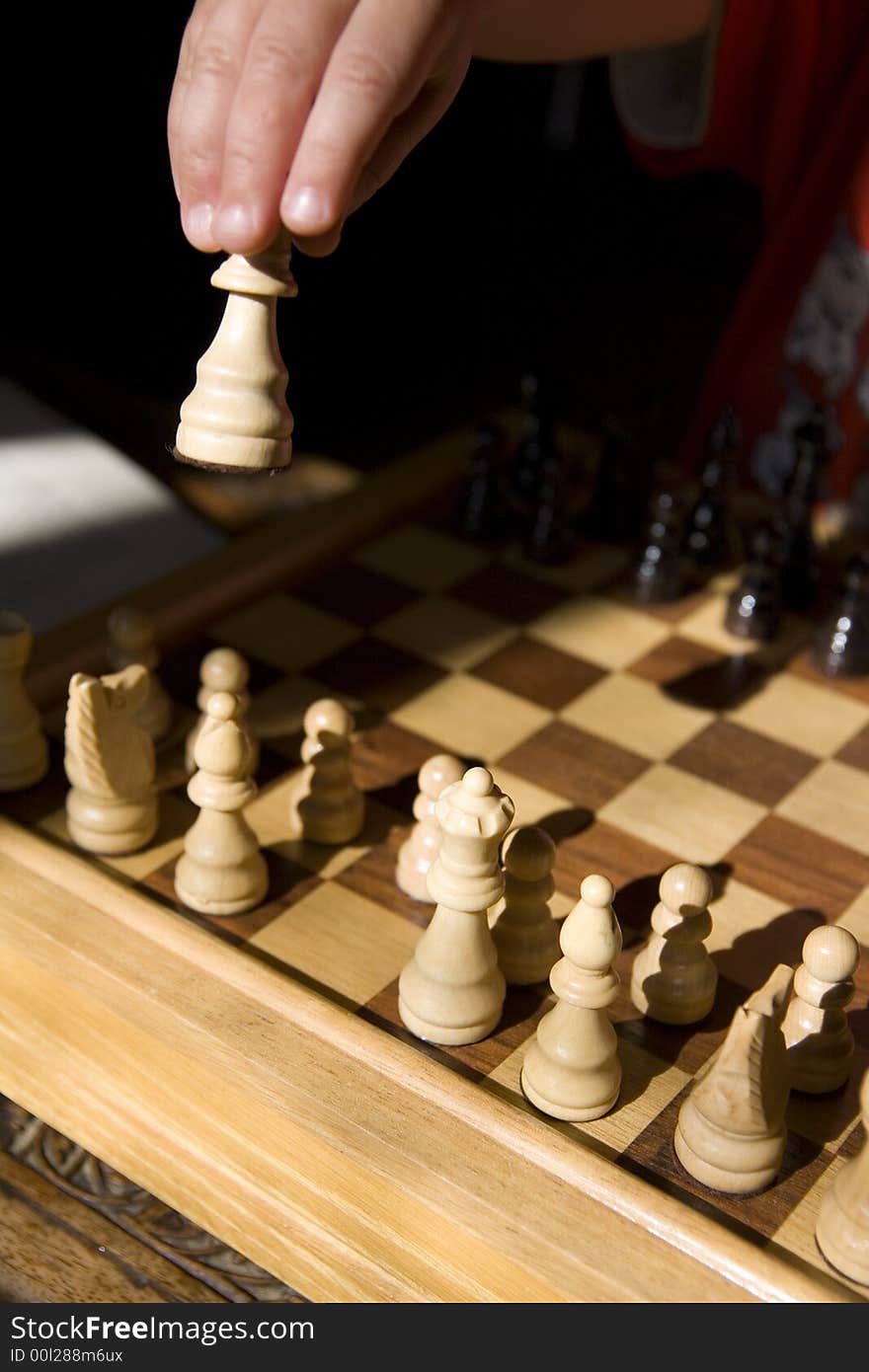 Young child playing chess on traditional wood chess set