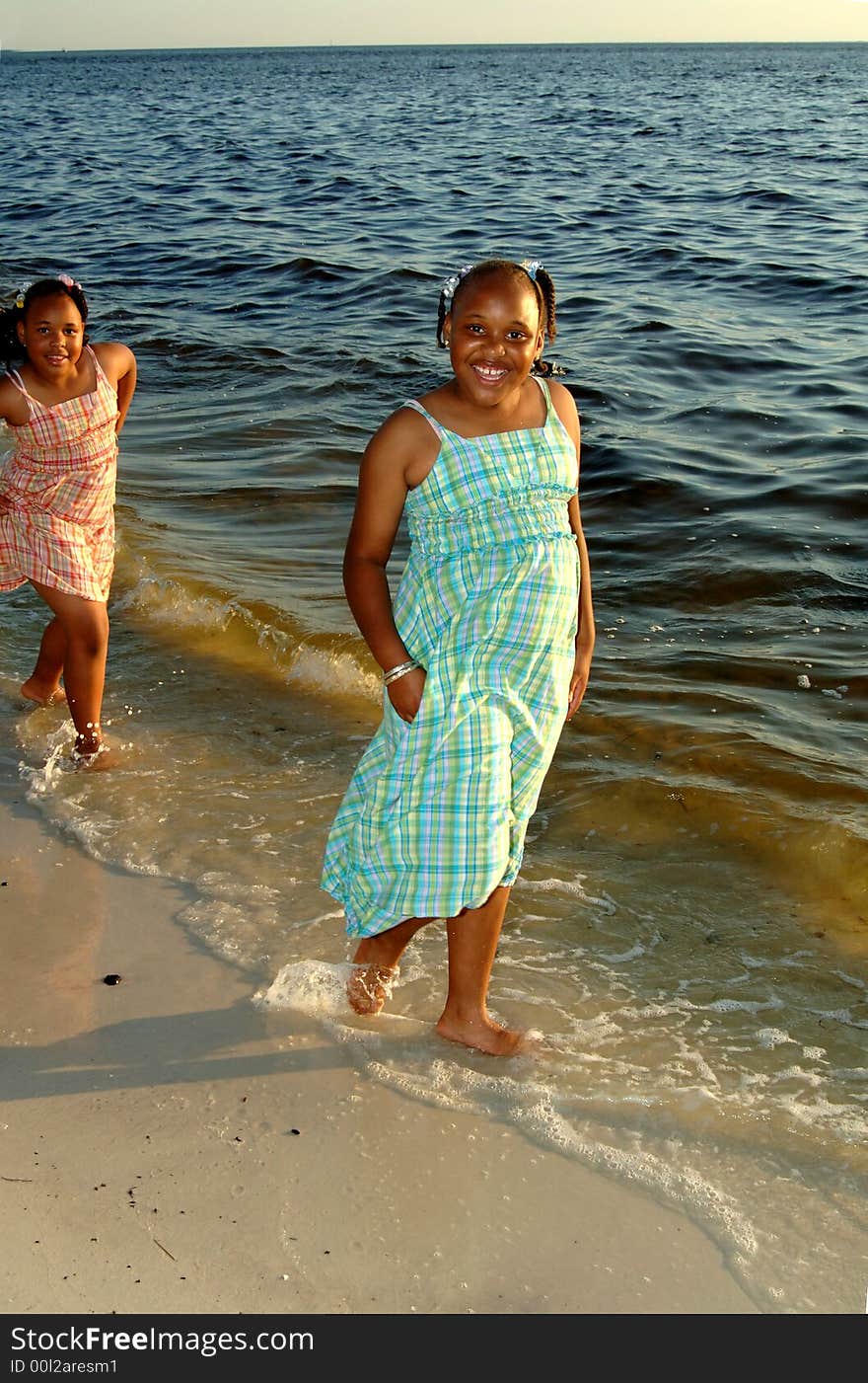 Two african american sisters walking along shoreline. Two african american sisters walking along shoreline