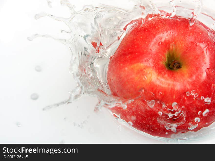 Delicious fresh apple with water splash over white.