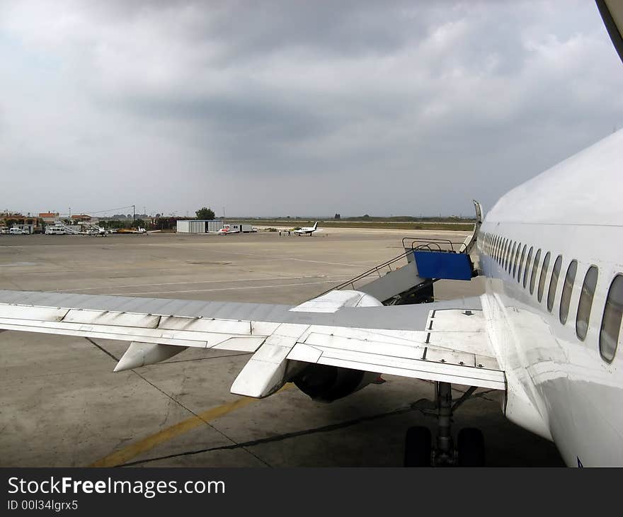 An aircraft side view from rear on a cloudy morning at the airport