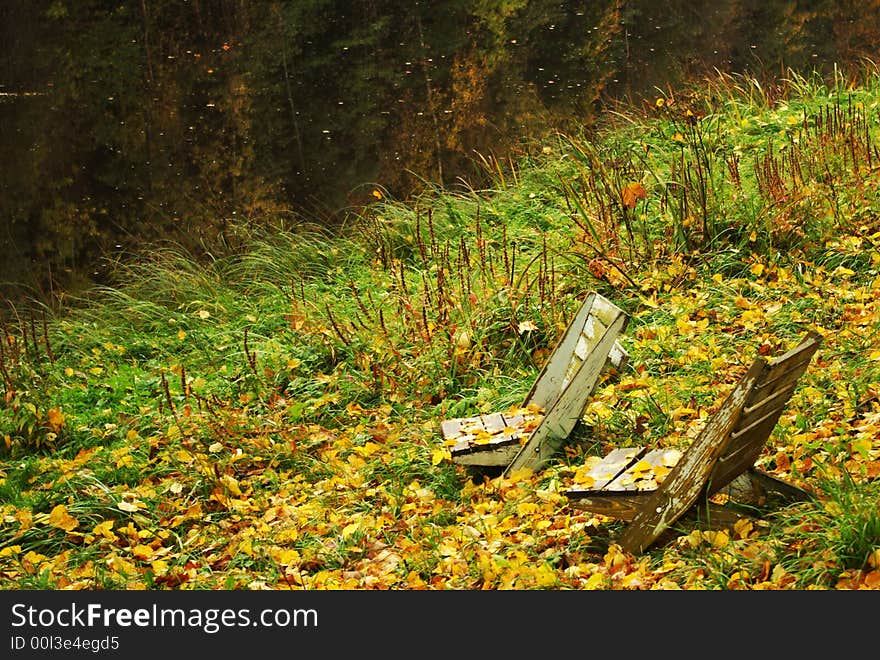 Two wooden chairs by river