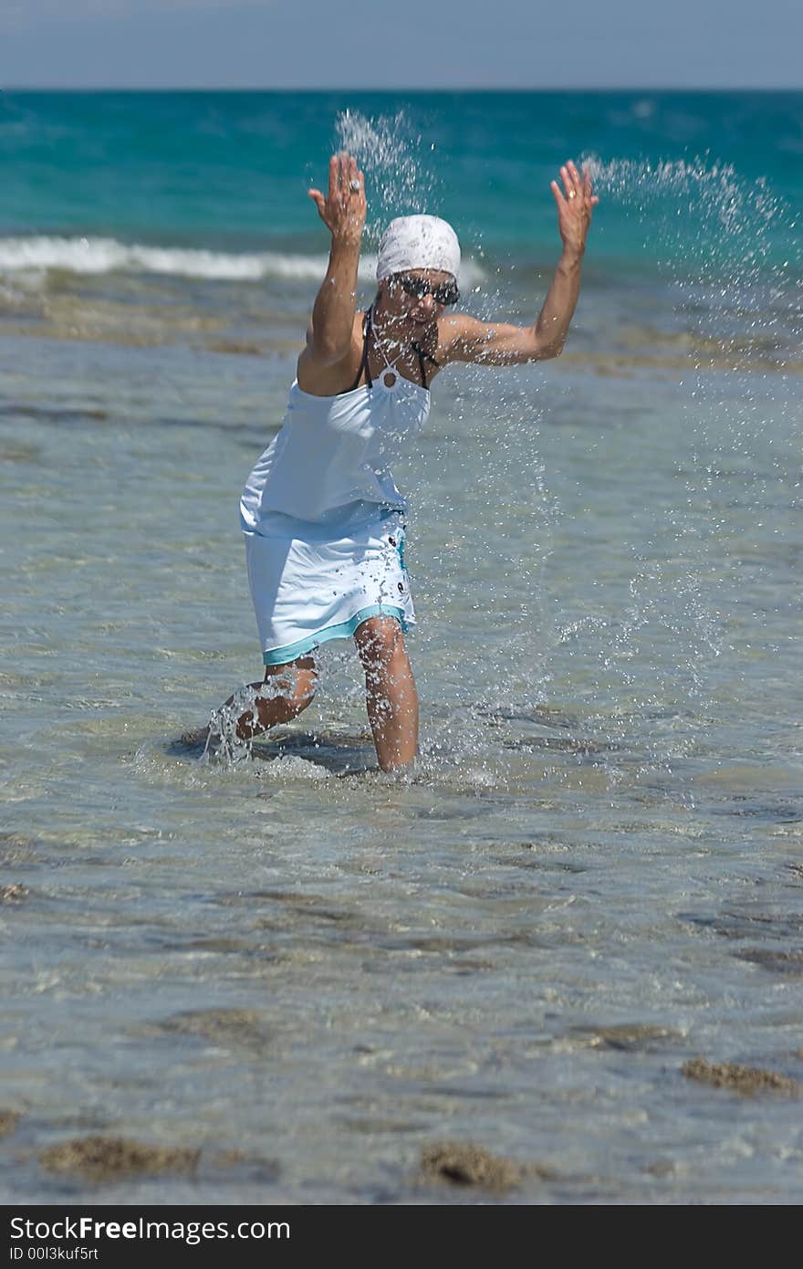 Woman being sprinkled at the seaside