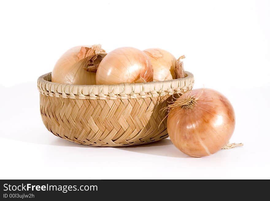 Group of onions on a basket isolated over white