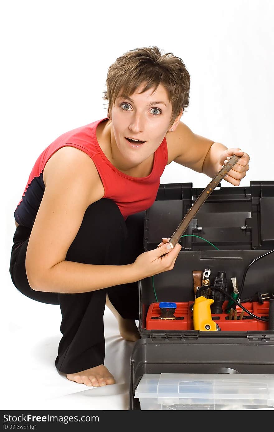 Portrait of young astonished brunette holding the saw. Portrait of young astonished brunette holding the saw