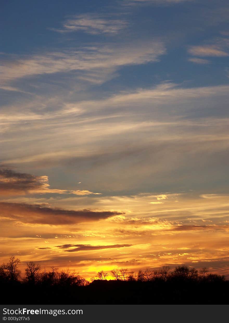 An orange sunset casting over a blue sky.