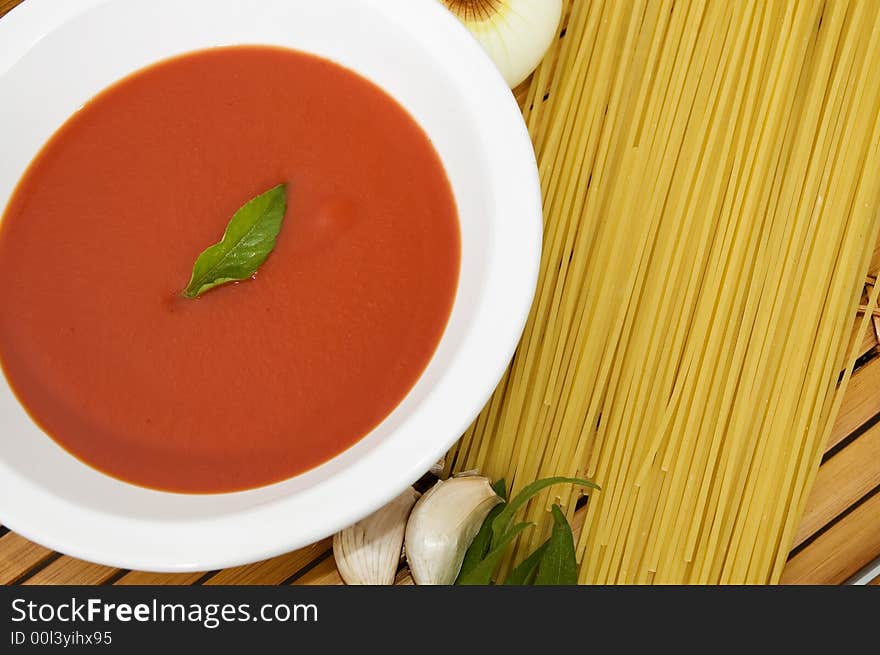 Spaghetti, tomato sauce, garlic and basil leaves on wood background. Spaghetti, tomato sauce, garlic and basil leaves on wood background