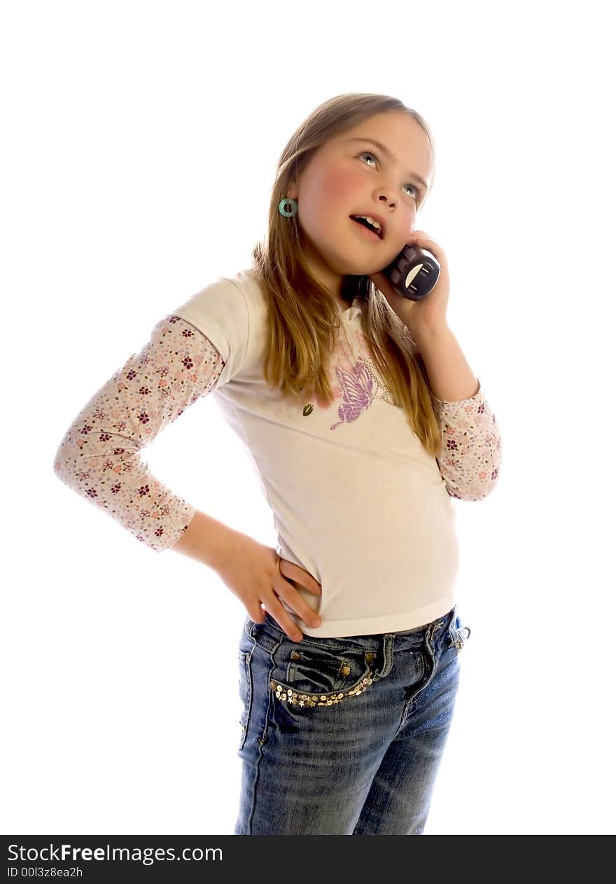 A young girl with long hair stands and listens to a phone conversation. White background. A young girl with long hair stands and listens to a phone conversation. White background.