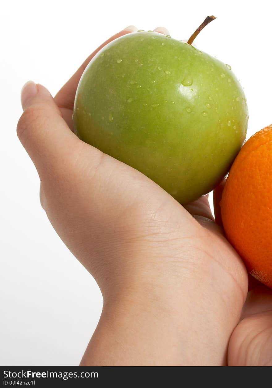 Holding a fresh green apple and an orange over a white background. Holding a fresh green apple and an orange over a white background