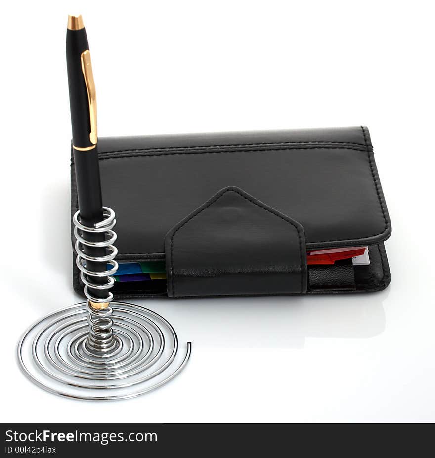 A pen and an organizer over a white background