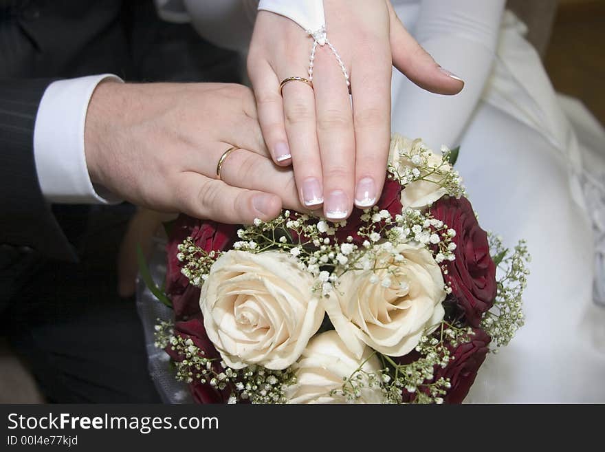 The hands of groom and bride on the flowers. The hands of groom and bride on the flowers