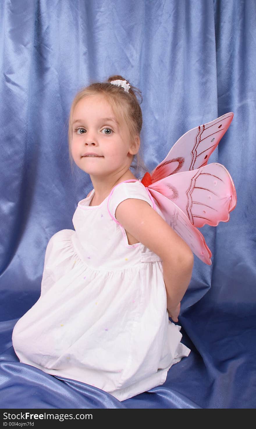 Young girl as butterfly on the blue background