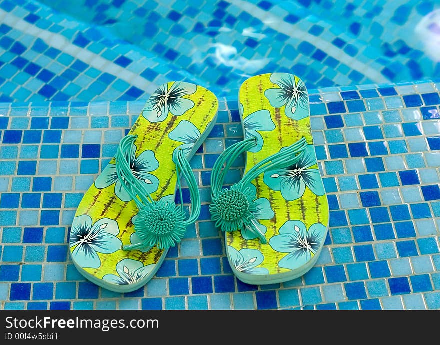 Sandals with flowers (flipflop, slippers) on the blue coast of pool. Sandals with flowers (flipflop, slippers) on the blue coast of pool