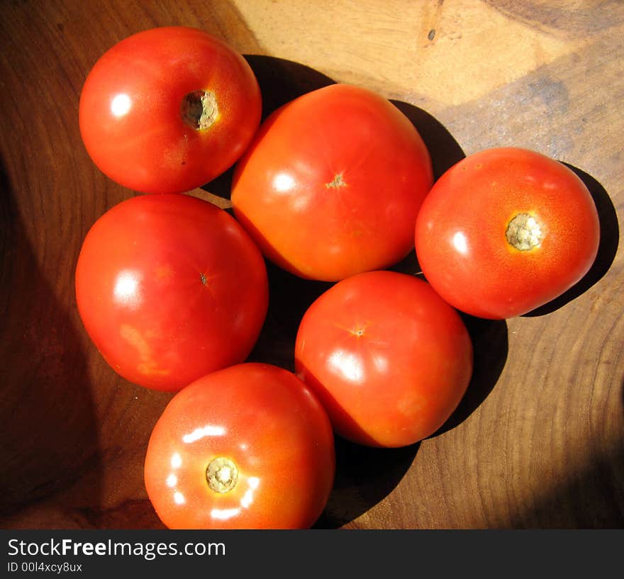 Some fresh tomatoes inside a wooden ball. Some fresh tomatoes inside a wooden ball